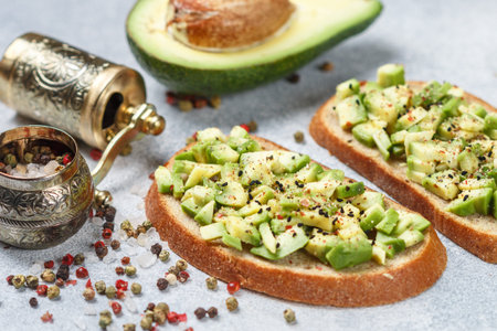 Slices of rye bread with avocado and spices colorful peppers and large sea salt, black sesame....