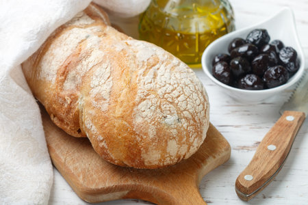 Ciabatta with olives. Fresh delicious traditional Italian bread, olives and olive oil on a white...
