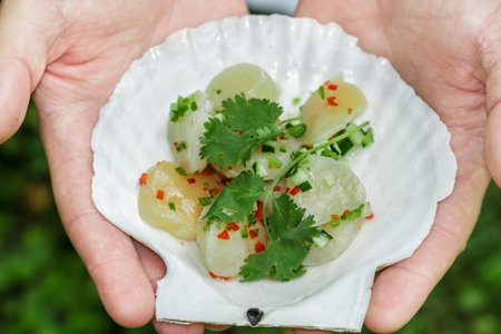 Delicatessen appetizer of fresh scallop with lemon or lime juice, chili pepper , red onion,...
