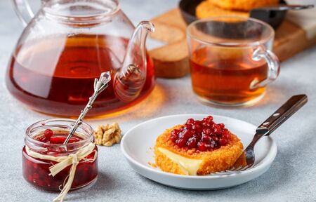 Baked or fried (grilled Camembert or brie cheese with cranberry (lingonberry, cowberry) sauce or jam. Gourmet traditional Breakfast. Selective focusの写真素材