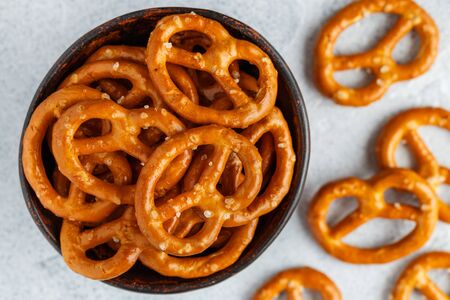 Mini pretzels with salt in a ceramic bowl close-up.の写真素材
