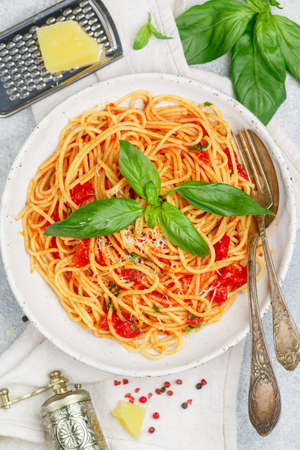 Spaghetti with tomato sauce, fresh Basil, Parmesan cheese, olive oil and spices. Mediterranean (Italian) cuisine. Delicious pasta. Vegetarian dish. Selective focusの写真素材