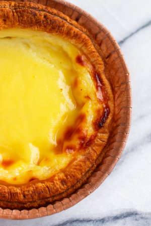 Egg tart, traditional Portuguese dessert, pastel de nata in a gray plate on a marble background. Portuguese puff close-up. Selective focusの写真素材