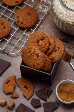 Freshly baked homemade vegan oatmeal cookies with chocolate chips and spices. Delicious healthy biscuits for tea. Selective focusの写真素材