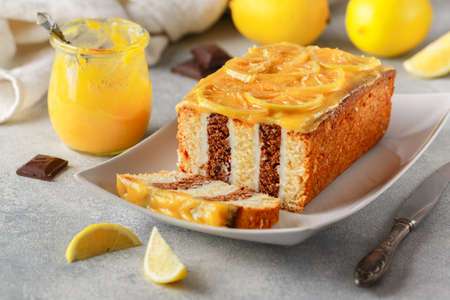 Homemade chocolate cake with cream and lemon curd. Striped Layer cake. Delicious sweet pastries. Citrus dessert. Rustic style. Selective focusの写真素材