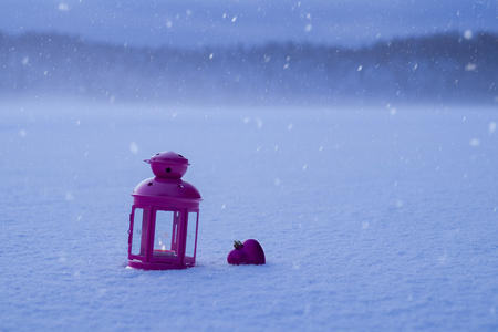 Christmas lantern and Christmas toy in the form of a heart in the snow. Lantern and tree toy on Christmas eveの写真素材