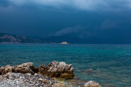 A rocky terrain by the water with clody skyの写真素材