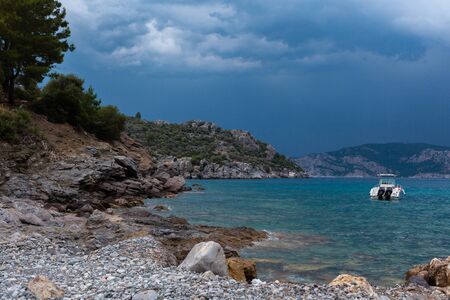 A rocky terrain by the water with clody skyの写真素材