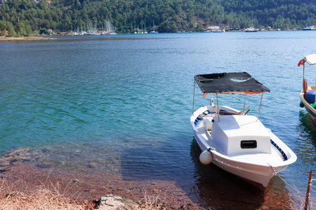 White small boat moored on the shore of the sea bay