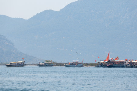 Tourist boats with Turkish flags on the background of mountainsの写真素材