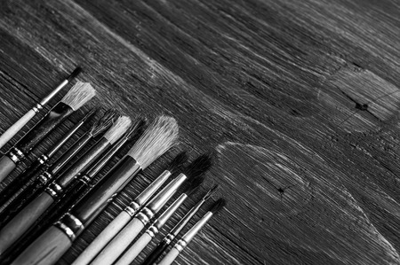 Row of artist paintbrushes closeup on artistic background.の写真素材