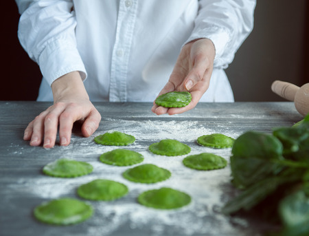 chef step by step, preparing a green ravioli with the addition of spinach dough, stuffed with ricotta and porcini mushrooms.の写真素材