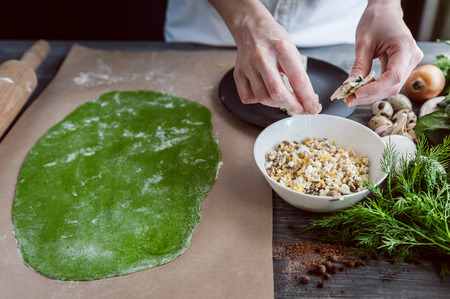 chef step by step, preparing a green ravioli with the addition of spinach dough, stuffed with ricotta and porcini mushrooms.の写真素材