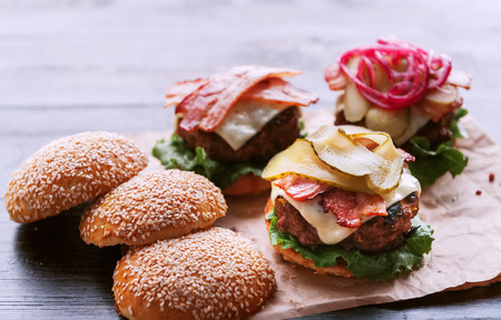 Ingredients for a tasty and juicy burger home in a rustic style with a big chop of beefの写真素材