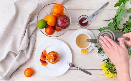 cheese pancake with citrus fruits and jam on a wooden table with tea. Breakfast conceptの写真素材