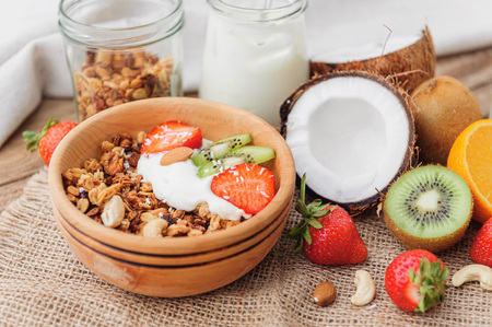 Granola with Greek yoghurt and fruit on a wooden background in a rustic styleの写真素材