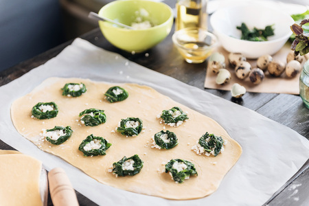 Step by step the chef prepares ravioli with ricotta cheese, yolks quail eggs and spinach with spices. The chef prepares the filling on the doughの写真素材