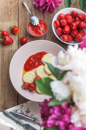 Dumplings from rice flour and cottage cheese with a pitted strawberryの写真素材