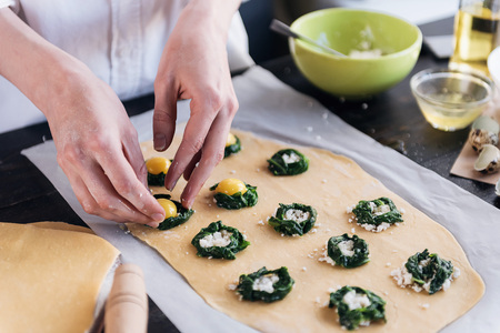 Step by step the chef prepares ravioli with ricotta cheese, yolks quail eggs and spinach with spices. The chef prepares the filling on the doughの写真素材