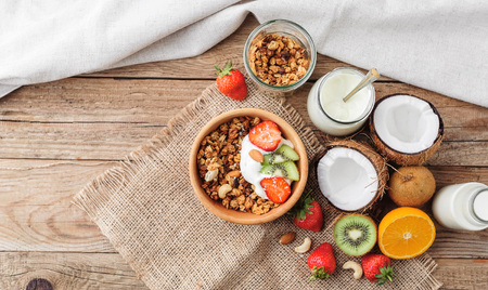 Granola with Greek yoghurt and fruit on a wooden background in a rustic styleの写真素材