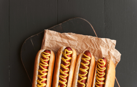 Barbecue Grilled Hot Dogs with  yellow American mustard, On a dark wooden backgroundの写真素材