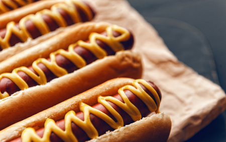 Barbecue Grilled Hot Dogs with  yellow American mustard, On a dark wooden backgroundの写真素材