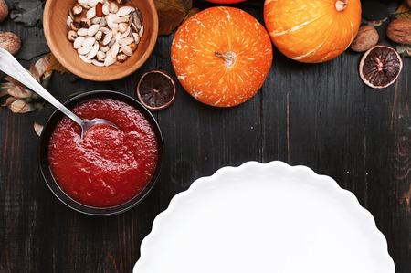 Chef cooks a pie for Halloween with a filling of pumpkin-strawberry jam and peachesの写真素材