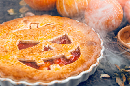 Delicious homemade pie for halloween with a filling of pumpkin-strawberry jam and peachesの写真素材
