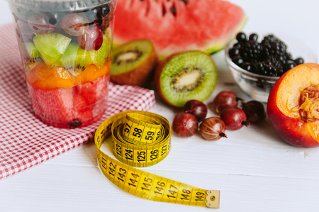 Fruit in a glass, a tape for measuring the body. Concept of healthy nutrition and weight lossの写真素材