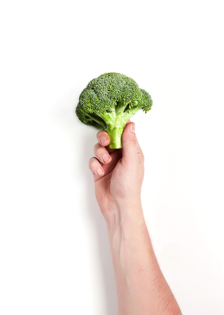broccoli in a male hand on a white backgroundの写真素材
