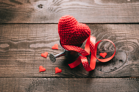 knitted hearts in a decorative watering canの写真素材