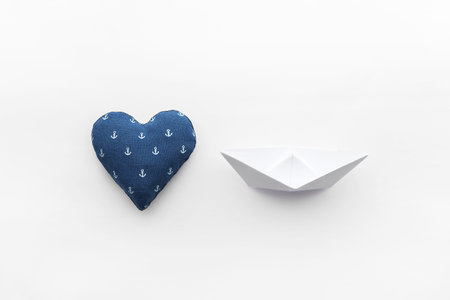 paper boats on a white matte background and heart with an anchorの写真素材