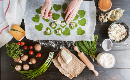 Chef cook step by step makes green ravioli in the shape of a heart for a festive dinnerの写真素材