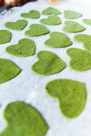 Chef cook step by step makes green ravioli in the shape of a heart for a festive dinnerの写真素材