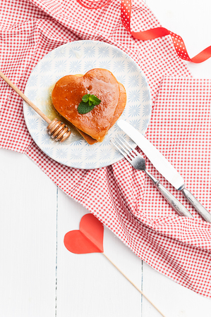 heart shaped pancakes on a light background. the concept of a festive breakfast for Valentine's Day or a pleasant surprise for a loved oneの写真素材