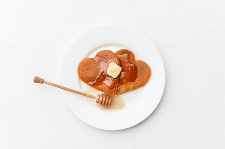 heart shaped pancakes on a light background. the concept of a festive breakfast for Valentine's Day or a pleasant surprise for a loved oneの写真素材