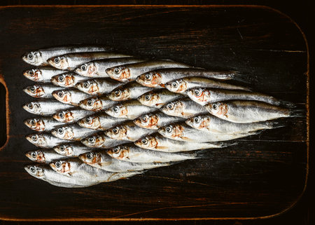 fresh raw fish anchovy and sprat on a wooden surface