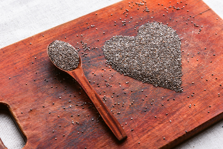 heart made of chia seeds on a wooden background. concept of health and healthy eatingの写真素材