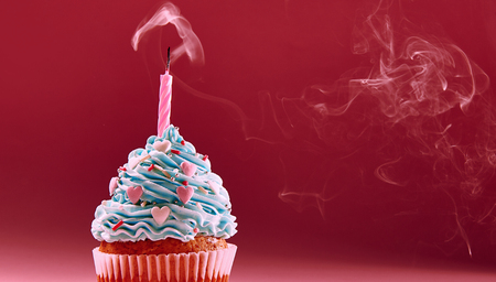muffin with cream and extinguished candle. the concept of the end of the celebration.の写真素材