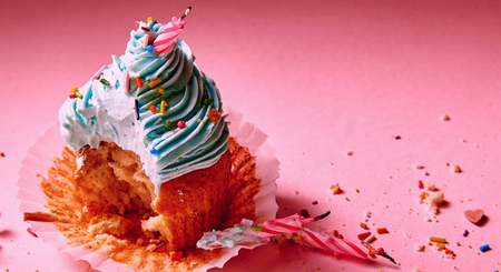 bitten muffin with cream with extinguished candlesの写真素材