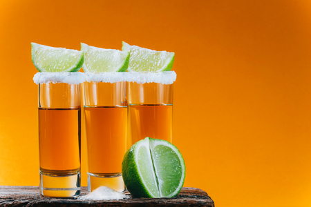 three glasses of tequila and pieces of limeの写真素材