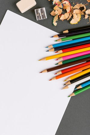 Color pencils on a gray background with a white sheet ready for drawingの写真素材
