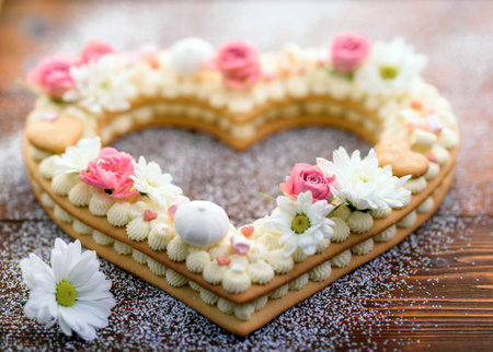 Valentine's Day heart-shaped cake with flowers as decoration. The concept of a gift to a loved one...