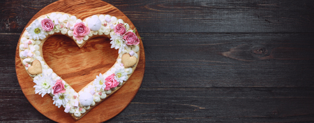Valentine's Day heart-shaped cake with flowers as decoration. The concept of a gift to a loved one on a holiday.の写真素材