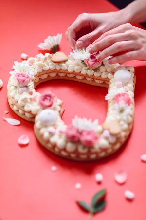 Valentine's Day heart-shaped cake with flowers as decoration. The concept of a gift to a loved one on a holiday.の写真素材