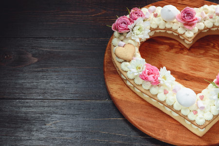 Valentine's Day heart-shaped cake with flowers as decoration. The concept of a gift to a loved one...