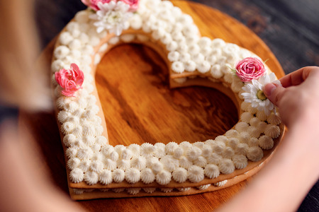 Valentine's Day heart-shaped cake with flowers as decoration. The concept of a gift to a loved one on a holiday.の写真素材