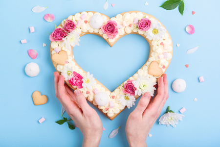 Valentine's Day heart-shaped cake with flowers as decoration. The concept of a gift to a loved one on a holiday.の写真素材