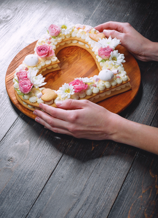 Valentine's Day heart-shaped cake with flowers as decoration. The concept of a gift to a loved one on a holiday.の写真素材