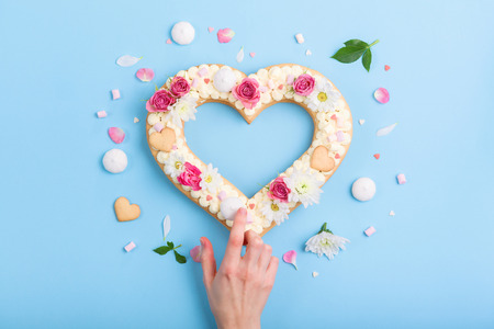 Valentine's Day heart-shaped cake with flowers as decoration. The concept of a gift to a loved one on a holiday.の写真素材